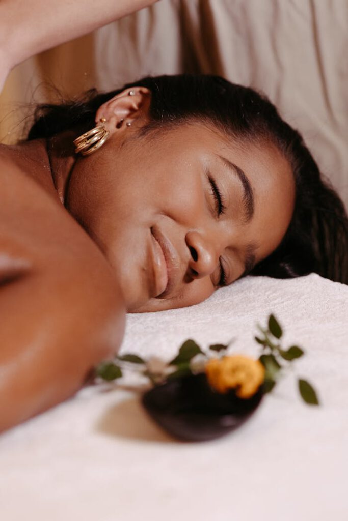 Woman enjoying a relaxing massage at a spa with serene ambiance and aromatherapy.